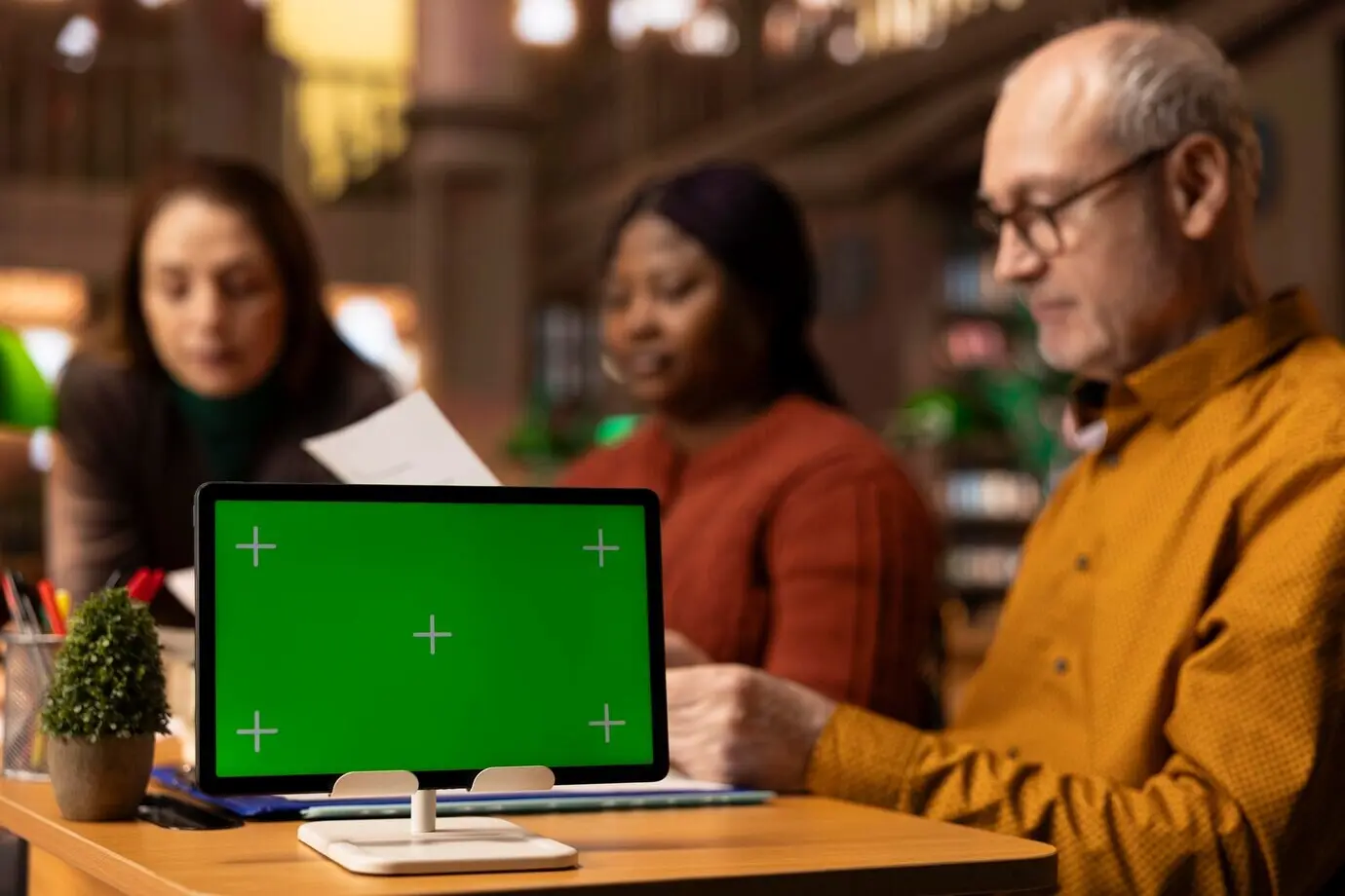 Команда спокойных и уравновешенных людей зрелого возраста, занимающихся учебой рядом со свободным пространством для текста.